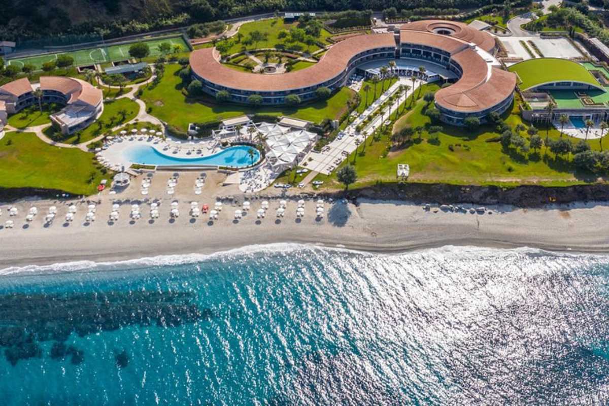 Veduta dall’alto della spiaggia di Tono con stabilimenti balneari, ombrelloni colorati e mare trasparente, Capovaticano in estate